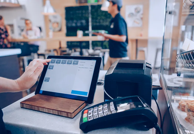 Point-of-sale terminal and a cup at a small café.